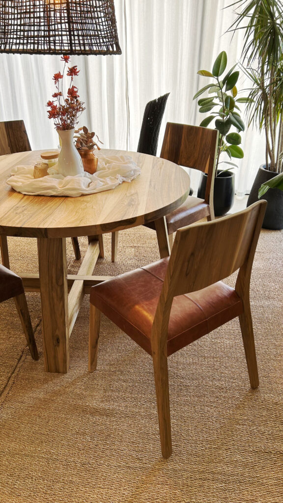 Silla Borneo de madera maciza y cuero vacuno junto a una mesa de comedor